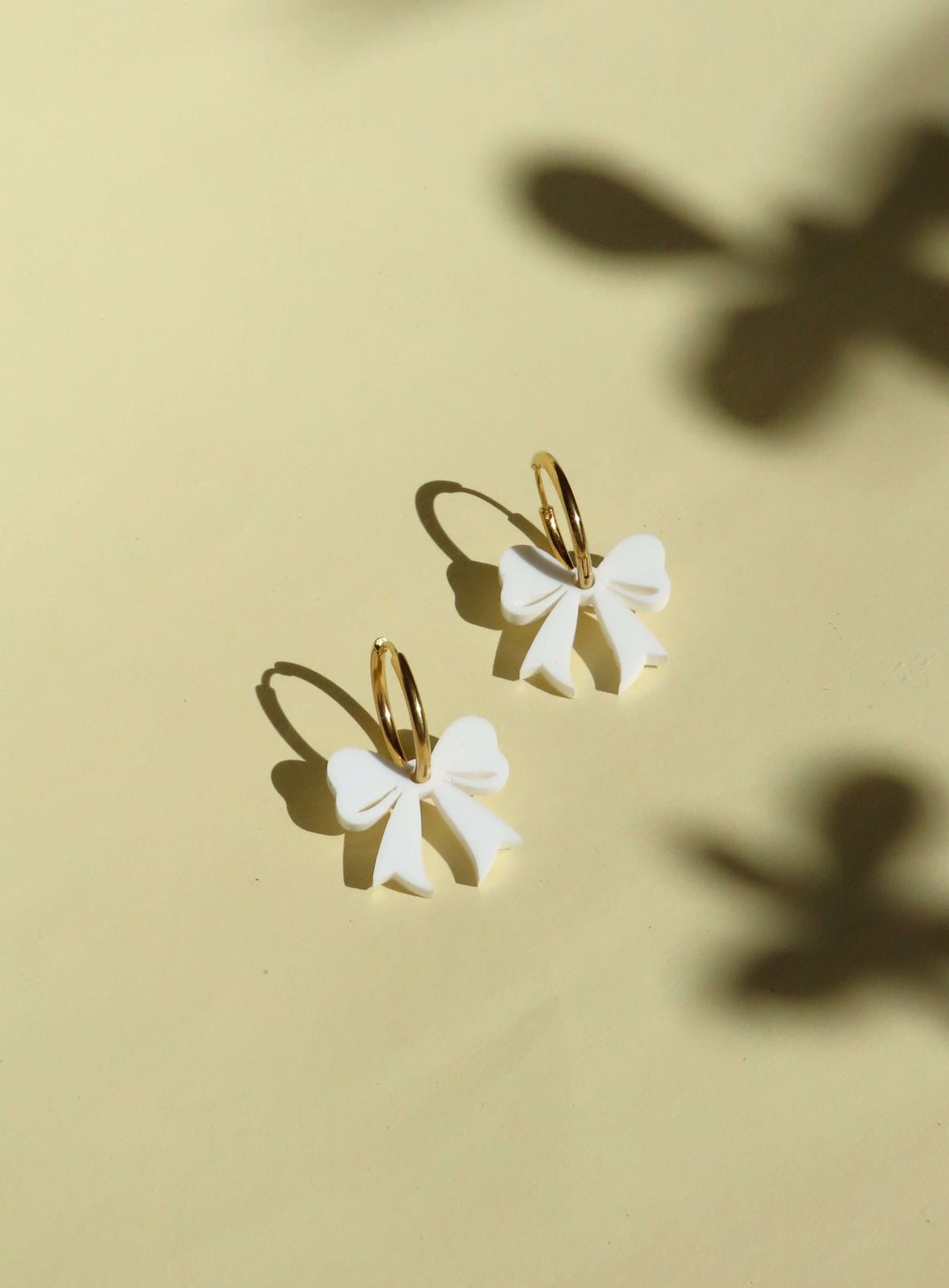 Goldene Creolen mit weißen Schleifen – verspielte Ohrringe mit 3D-Effekt